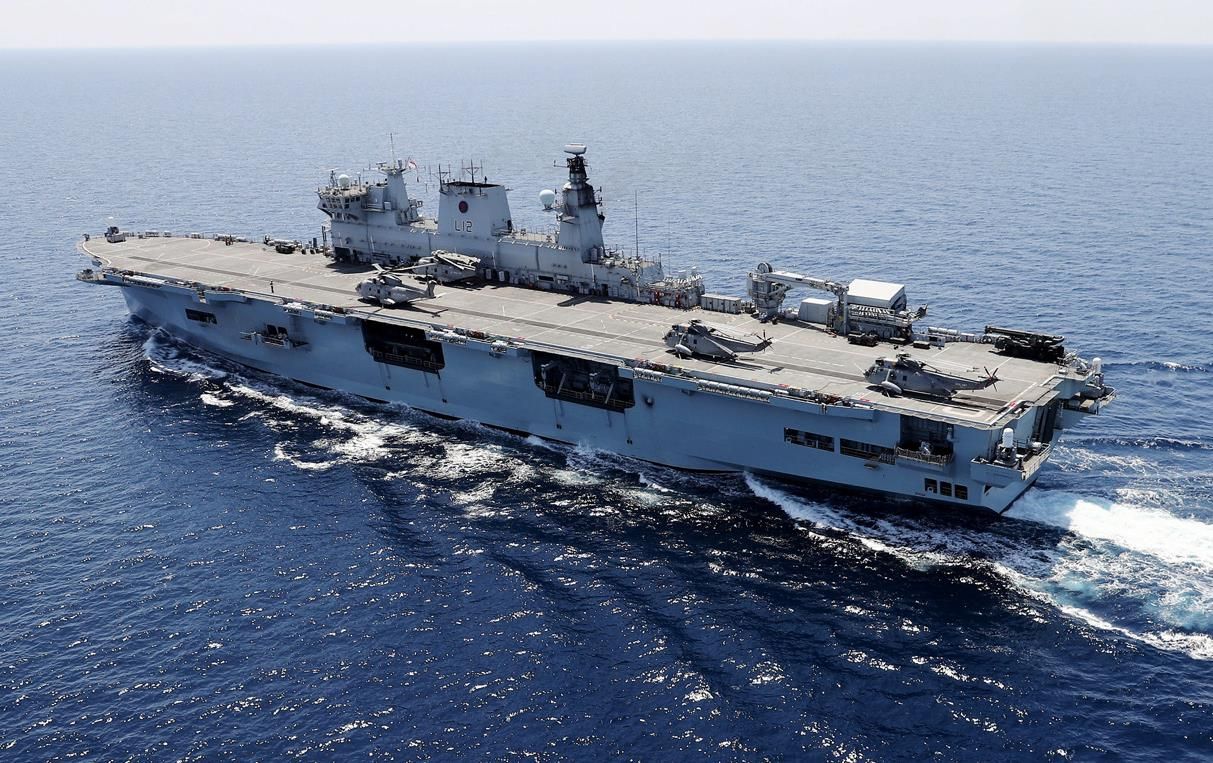 An Aircraft Carrier Is In The Middle Of The Ocean With Water Around It