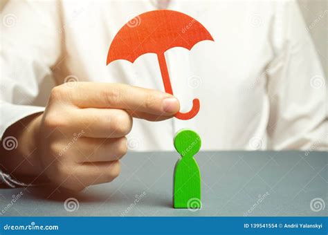 An Insurance Agent Holds A Red Umbrella Over A Human Figure Concept Of