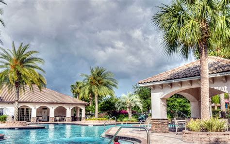 The Exterior Of A Hotel With Palm Trees In Front Of It At Night And