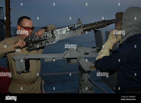 Us Navy Chief Aviation Ordnanceman Assists A Sailor From The Weapons